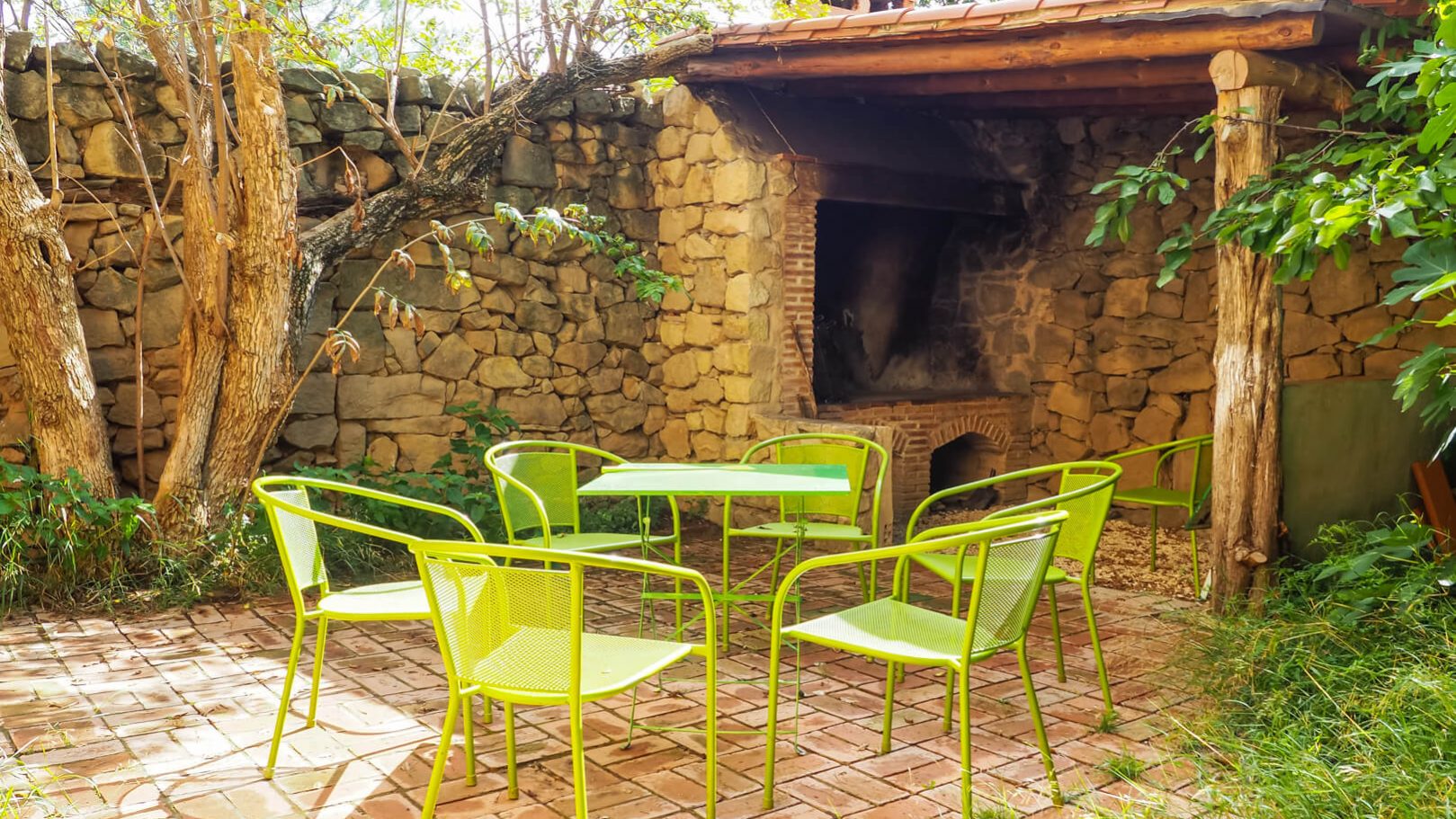 Foto de una terraza con una barbacoa, una mesa y unas sillas alrededor en La Artiga