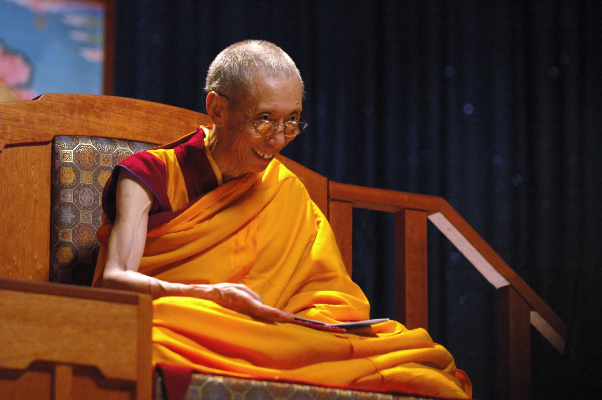 Gueshe-Kelsang-Gyatso monje en trono sonriendo